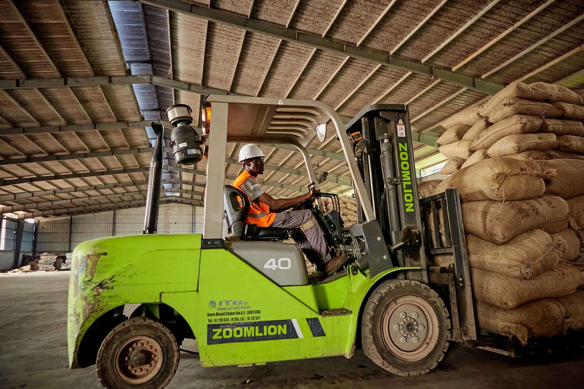 Forklift moving jute sacks of raw cashew nuts in a warehouse